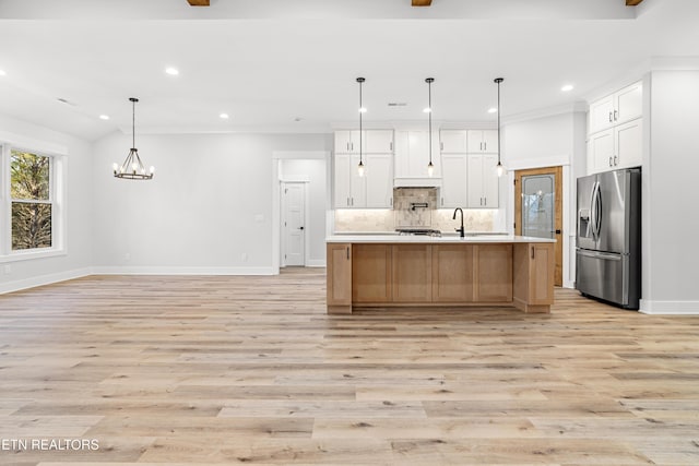 kitchen with tasteful backsplash, stainless steel fridge with ice dispenser, light wood-style flooring, light countertops, and recessed lighting