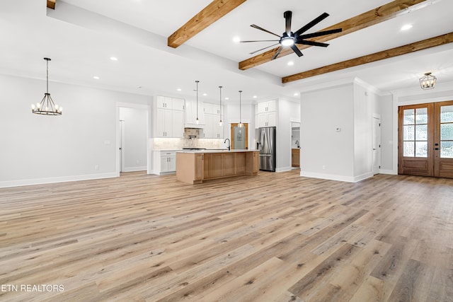 kitchen with open floor plan, light countertops, french doors, beam ceiling, and stainless steel fridge with ice dispenser