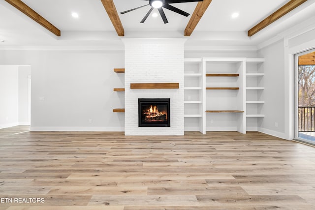 unfurnished living room with a brick fireplace, light wood-style flooring, beamed ceiling, and recessed lighting