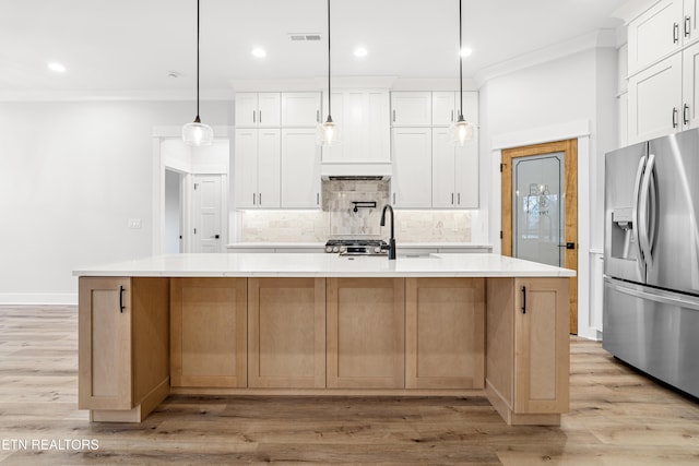 kitchen with decorative backsplash, stainless steel fridge with ice dispenser, light countertops, crown molding, and a sink