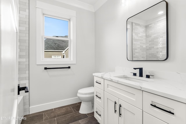 bathroom featuring baseboards, vanity, and toilet