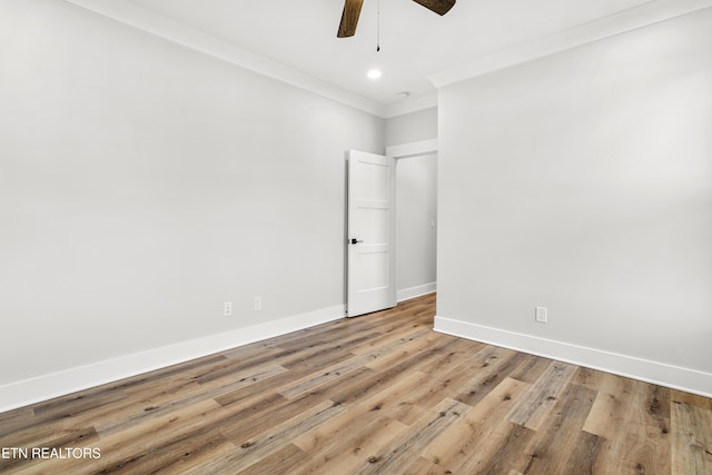 unfurnished room with crown molding, light wood finished floors, baseboards, and ceiling fan