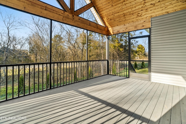 unfurnished sunroom with lofted ceiling with skylight