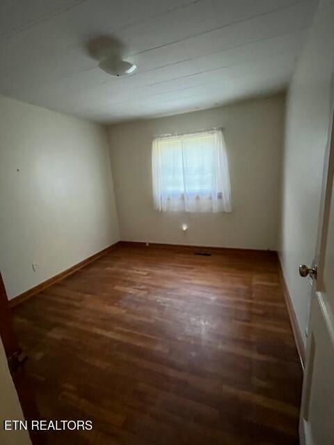 empty room featuring baseboards and wood finished floors