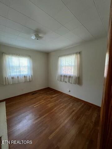 empty room with a wealth of natural light and wood finished floors