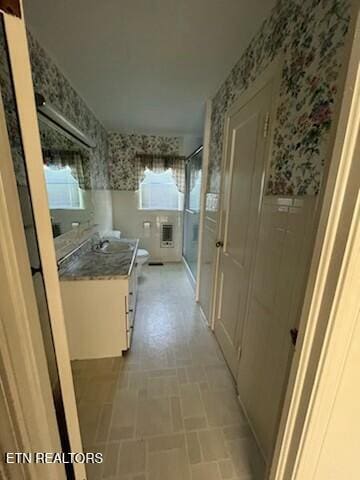 hallway with wallpapered walls and a sink