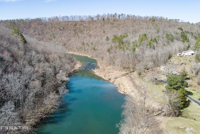 birds eye view of property featuring a wooded view and a water view