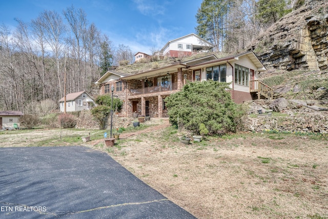 view of front of house featuring stairs and brick siding