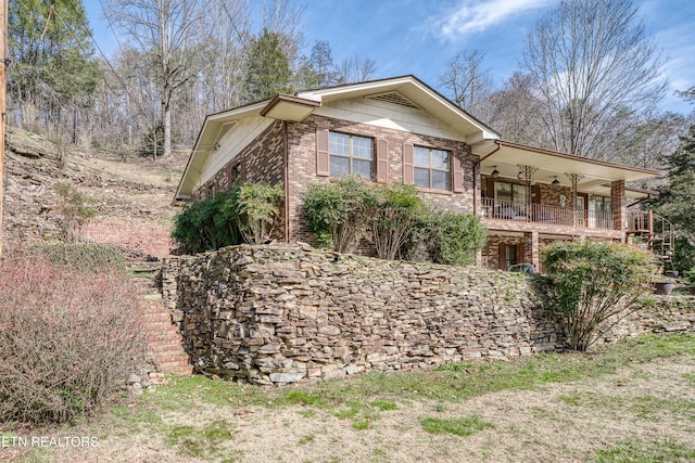 view of property exterior featuring brick siding and stairs