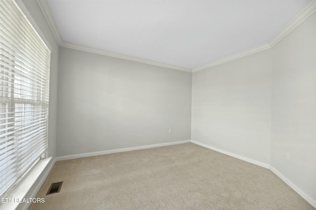 carpeted spare room featuring baseboards, visible vents, and ornamental molding