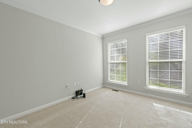 spare room with visible vents, baseboards, ornamental molding, and carpet flooring