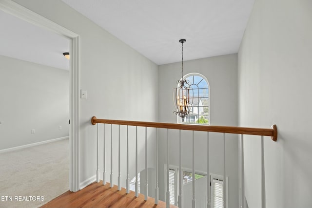 stairs featuring baseboards, carpet, and a chandelier