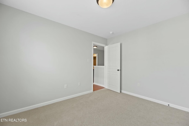 unfurnished room with carpet and baseboards