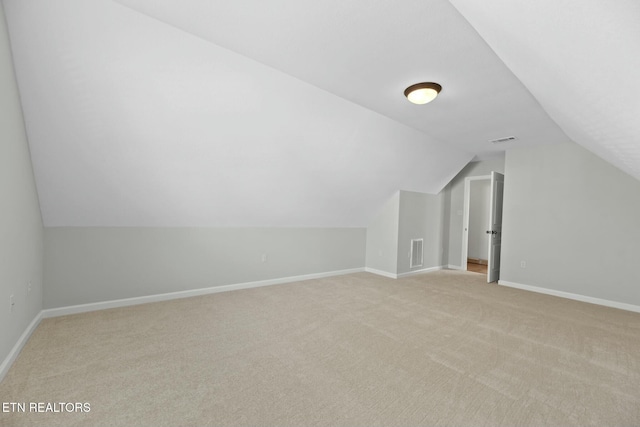 bonus room featuring visible vents, baseboards, lofted ceiling, and light carpet