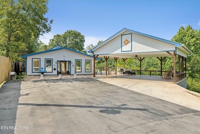 view of front facade featuring a ceiling fan, fence, and concrete driveway