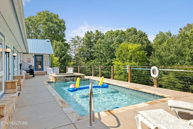 view of pool featuring a patio area, a pool with connected hot tub, and fence