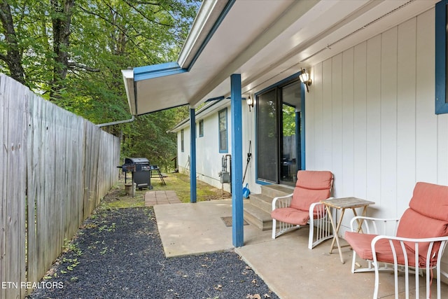 view of patio with entry steps, a fenced backyard, and a grill