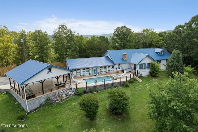 back of property with fence, metal roof, a lawn, and a gazebo