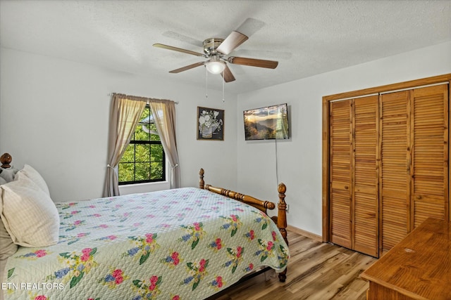 bedroom with a closet, ceiling fan, a textured ceiling, and wood finished floors