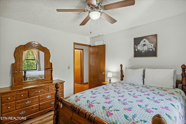 bedroom featuring a ceiling fan, a textured ceiling, and wood finished floors