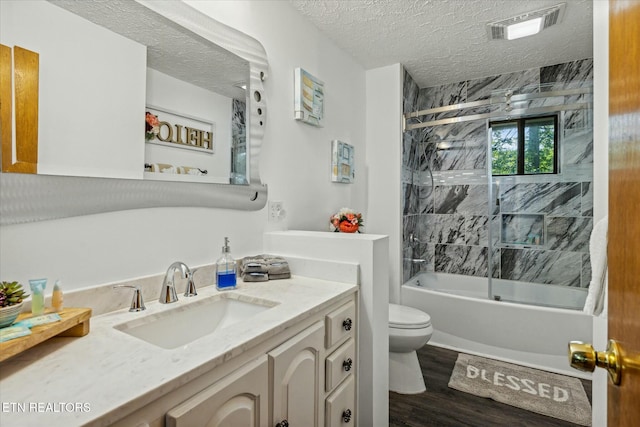 full bath featuring visible vents, toilet, shower / tub combination, wood finished floors, and a textured ceiling