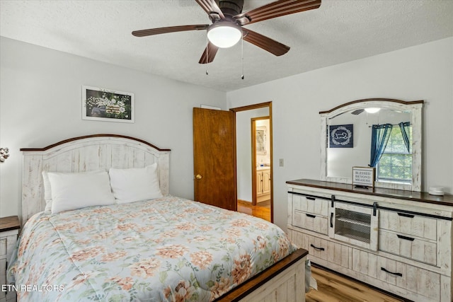 bedroom with a textured ceiling, wood finished floors, and a ceiling fan