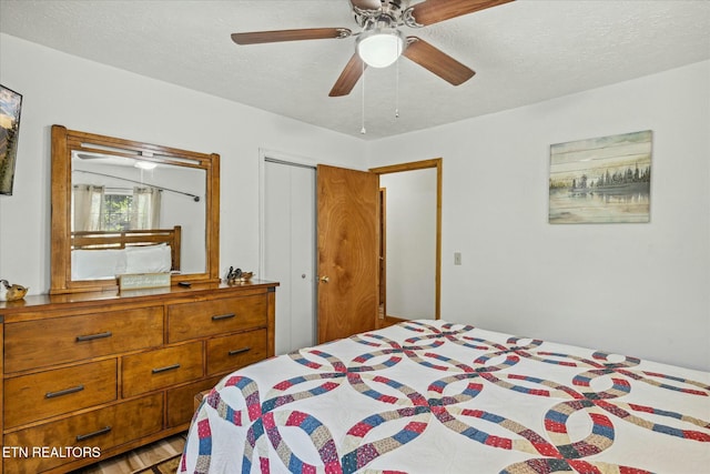 bedroom featuring ceiling fan, a closet, and a textured ceiling