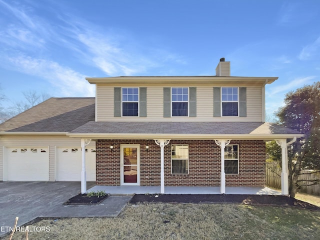 traditional home with covered porch, brick siding, a chimney, and an attached garage