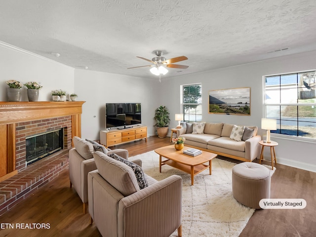 living area with a textured ceiling, a fireplace, and wood finished floors