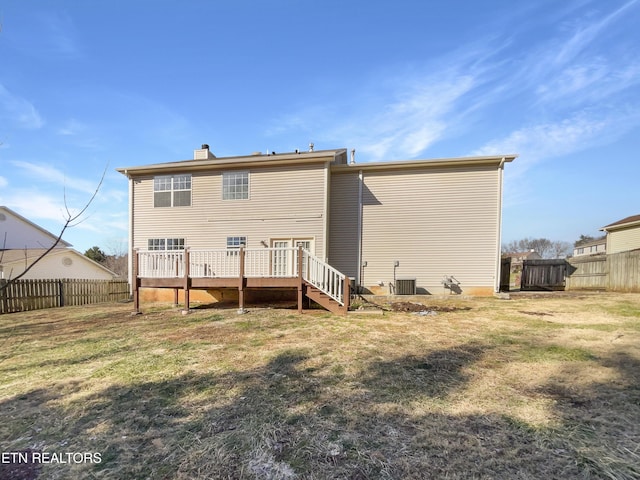 back of house featuring a deck, a fenced backyard, central air condition unit, a yard, and a chimney