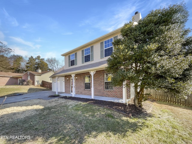 view of front of house with covered porch, brick siding, fence, driveway, and a front lawn