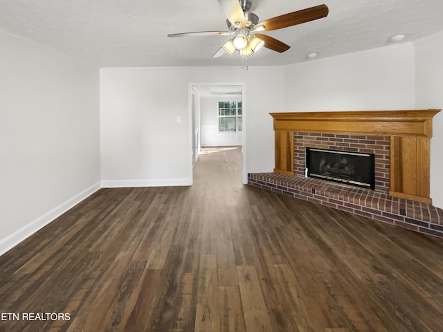 unfurnished living room with baseboards, a brick fireplace, wood finished floors, and crown molding