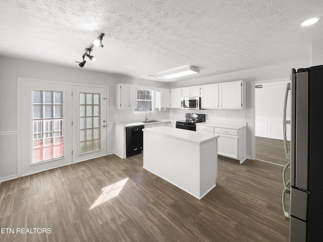 kitchen featuring dark wood finished floors, white cabinets, a kitchen island, a sink, and black appliances