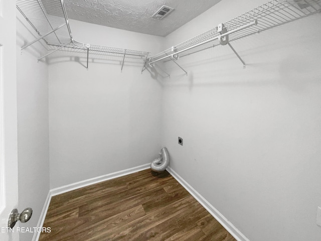 clothes washing area with laundry area, visible vents, baseboards, dark wood finished floors, and hookup for an electric dryer