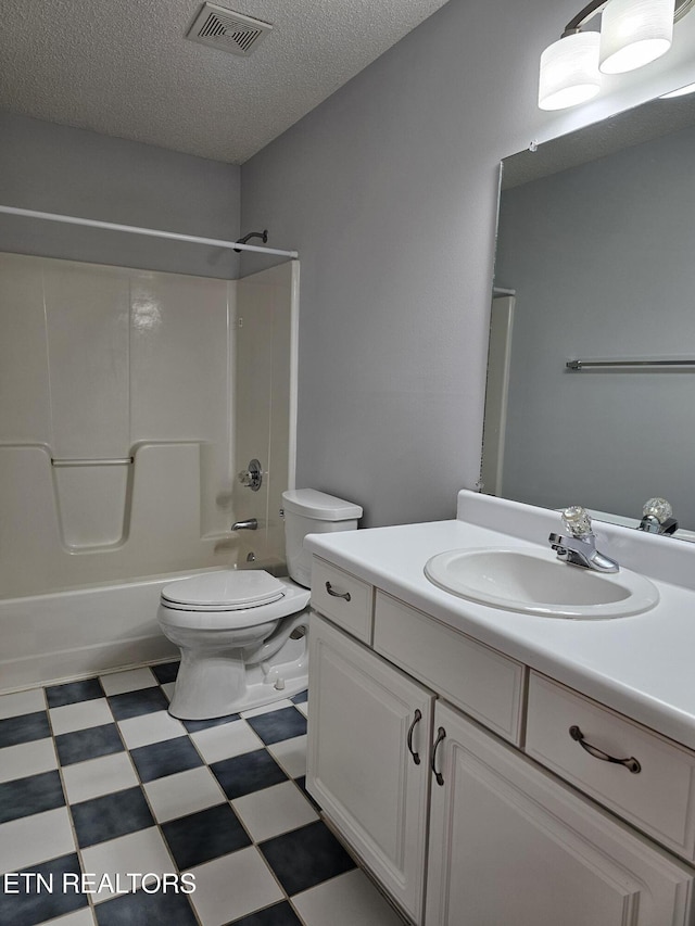 bathroom featuring a textured ceiling, toilet, vanity, visible vents, and tile patterned floors