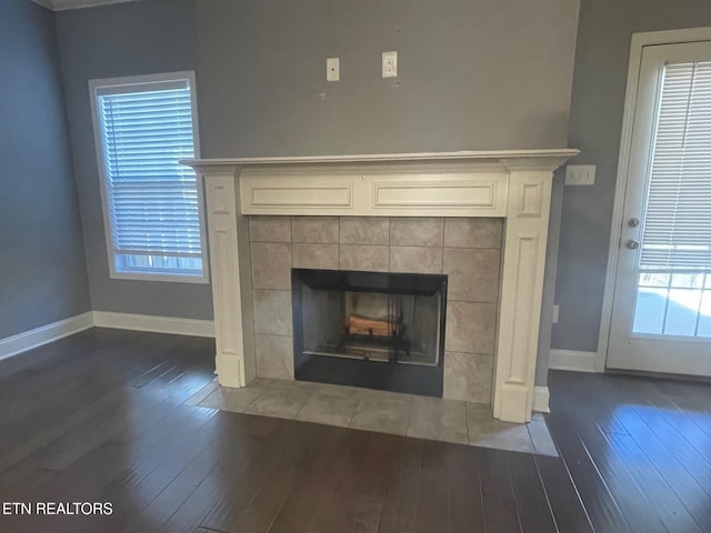 interior details featuring a fireplace, baseboards, and wood finished floors