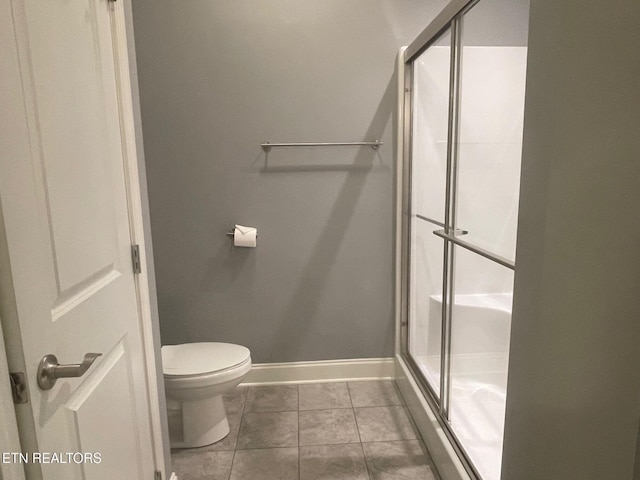 full bathroom with tile patterned flooring, toilet, baseboards, and a stall shower