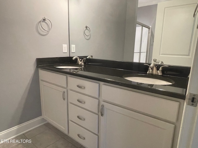 full bathroom featuring tile patterned floors, double vanity, baseboards, and a sink