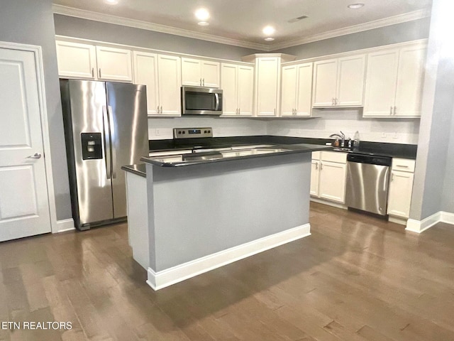 kitchen with appliances with stainless steel finishes, white cabinetry, and dark wood-type flooring