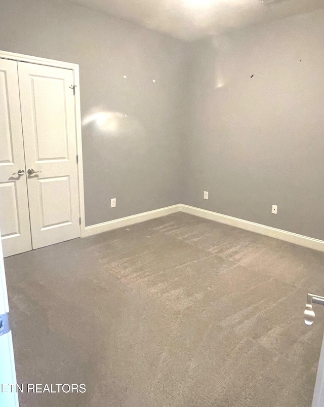 unfurnished room with baseboards