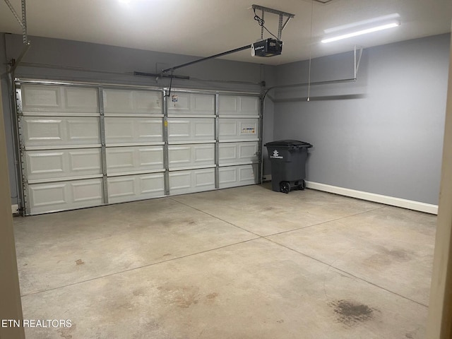 garage with baseboards and a garage door opener