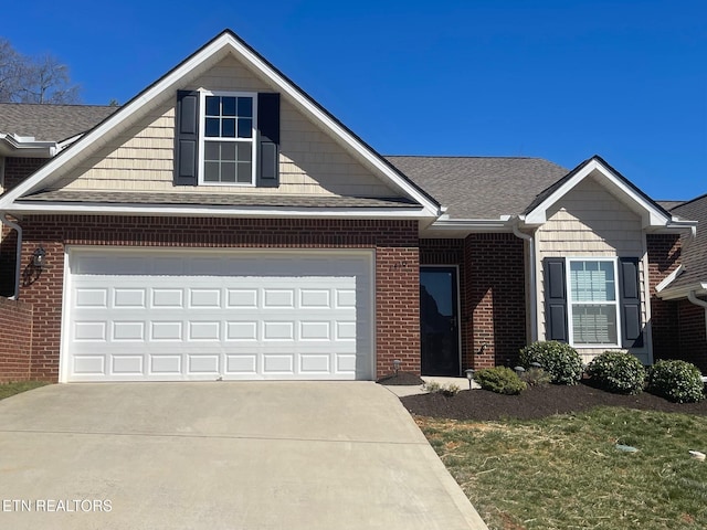 view of front facade with brick siding, concrete driveway, a garage, and roof with shingles