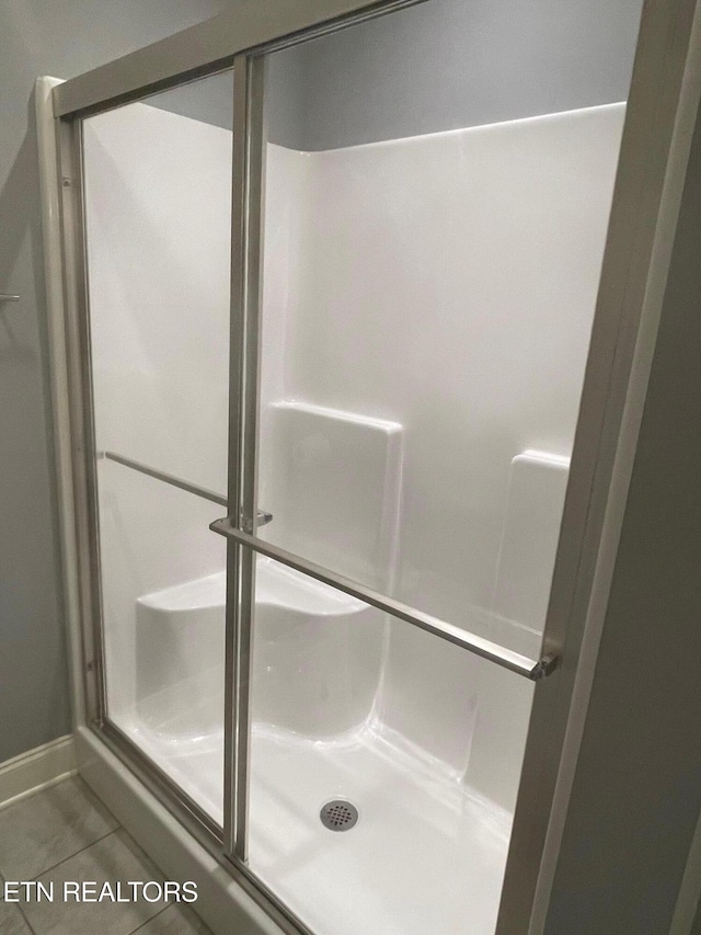 full bathroom featuring tile patterned flooring and a stall shower