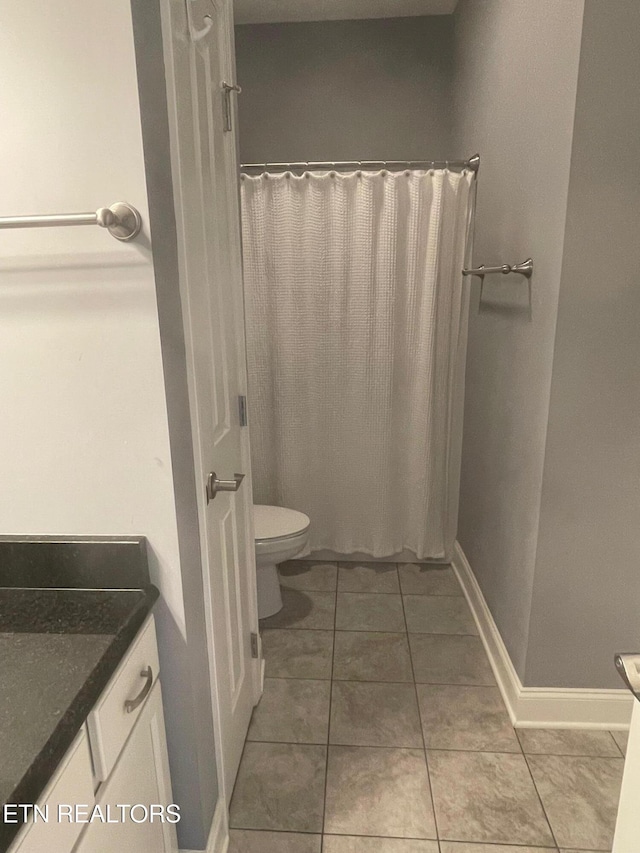 full bathroom featuring vanity, a shower with shower curtain, baseboards, tile patterned floors, and toilet