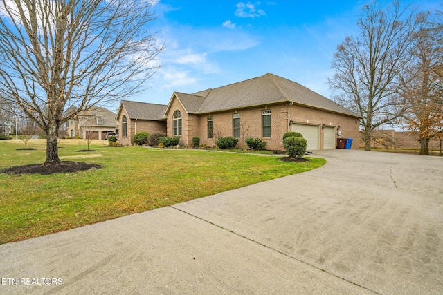 view of front of property with driveway, a garage, brick siding, fence, and a front yard