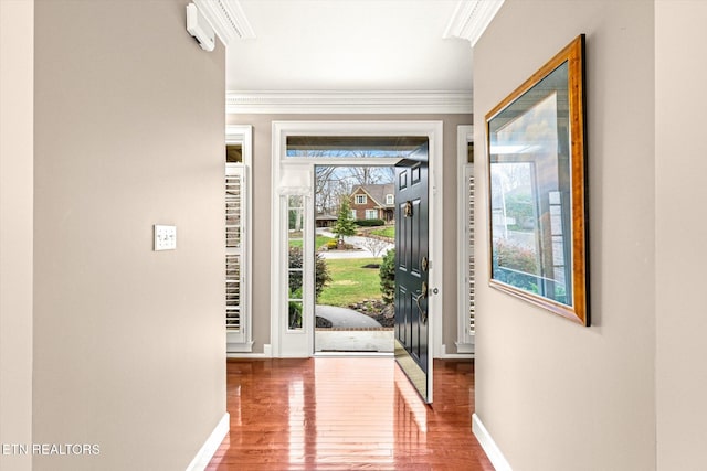 entryway featuring ornamental molding, a healthy amount of sunlight, baseboards, and hardwood / wood-style flooring