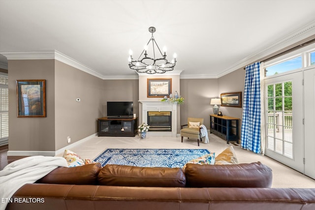 carpeted living area featuring ornamental molding, an inviting chandelier, a glass covered fireplace, and baseboards