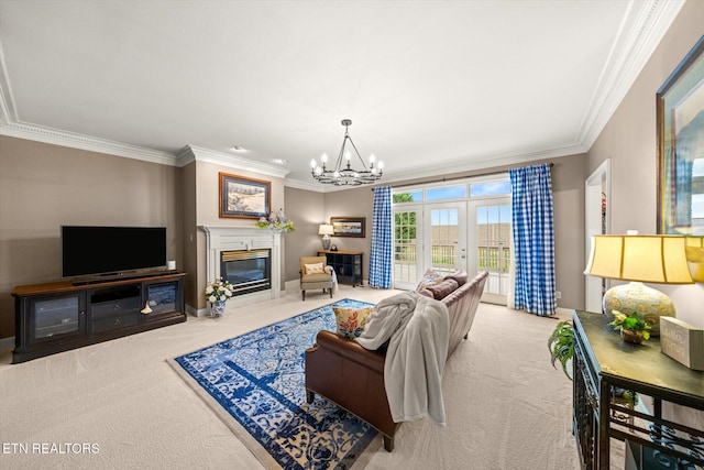 carpeted living room featuring baseboards, ornamental molding, a glass covered fireplace, and an inviting chandelier