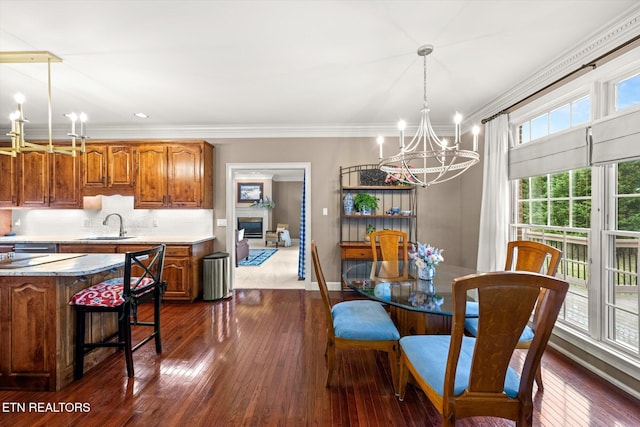 dining space featuring an inviting chandelier, baseboards, dark wood finished floors, and crown molding