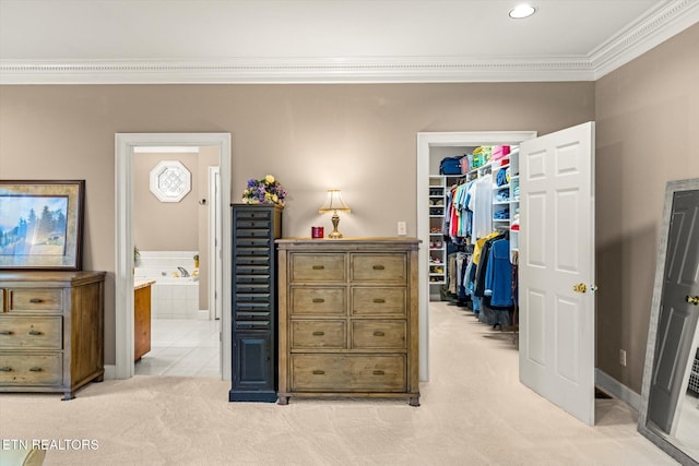 bedroom featuring a closet, a spacious closet, ornamental molding, light carpet, and connected bathroom